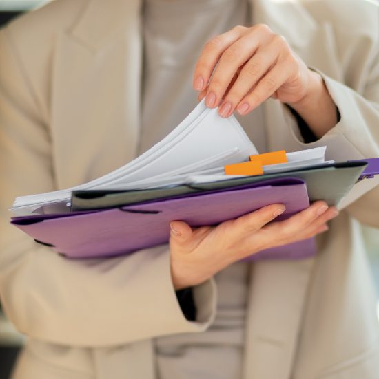 Person holding documents and files for logistics management.